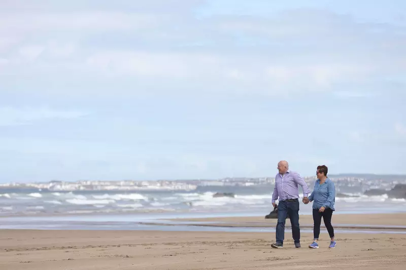 David and Elaine walking on the beach