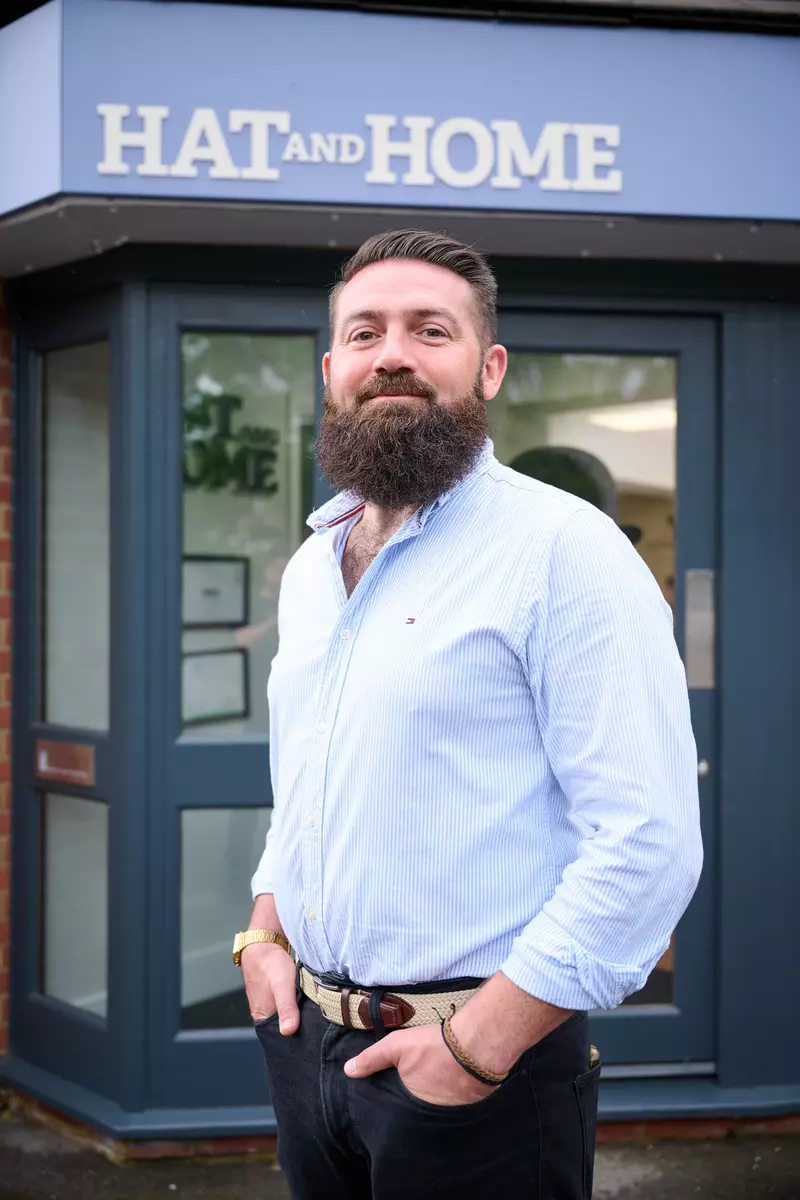 Ben stands proudly outside his estate agency business